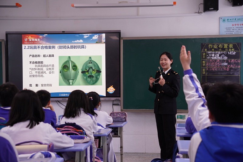 图为：关员在向学生介绍玩具安全知识